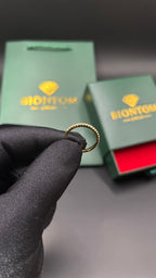 BIONTOMのゴールドメッキ仕上げの繊細なモアサナイトリング。ギフトボックスとショッパーが背景に写る高級感あるデザイン。