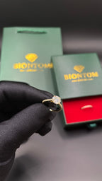BIONTOMのエレガントなモアサナイトリングセット。ゴールドの台座に大粒の石が輝き、ギフトボックスとショッパーが添えられた高級感あるデザイン。